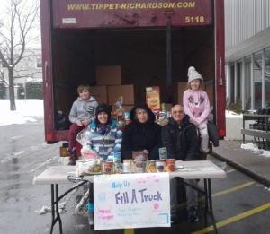 Volunteers for the Ottawa Food Drive are stationed behind a red Tipper Richardson truck