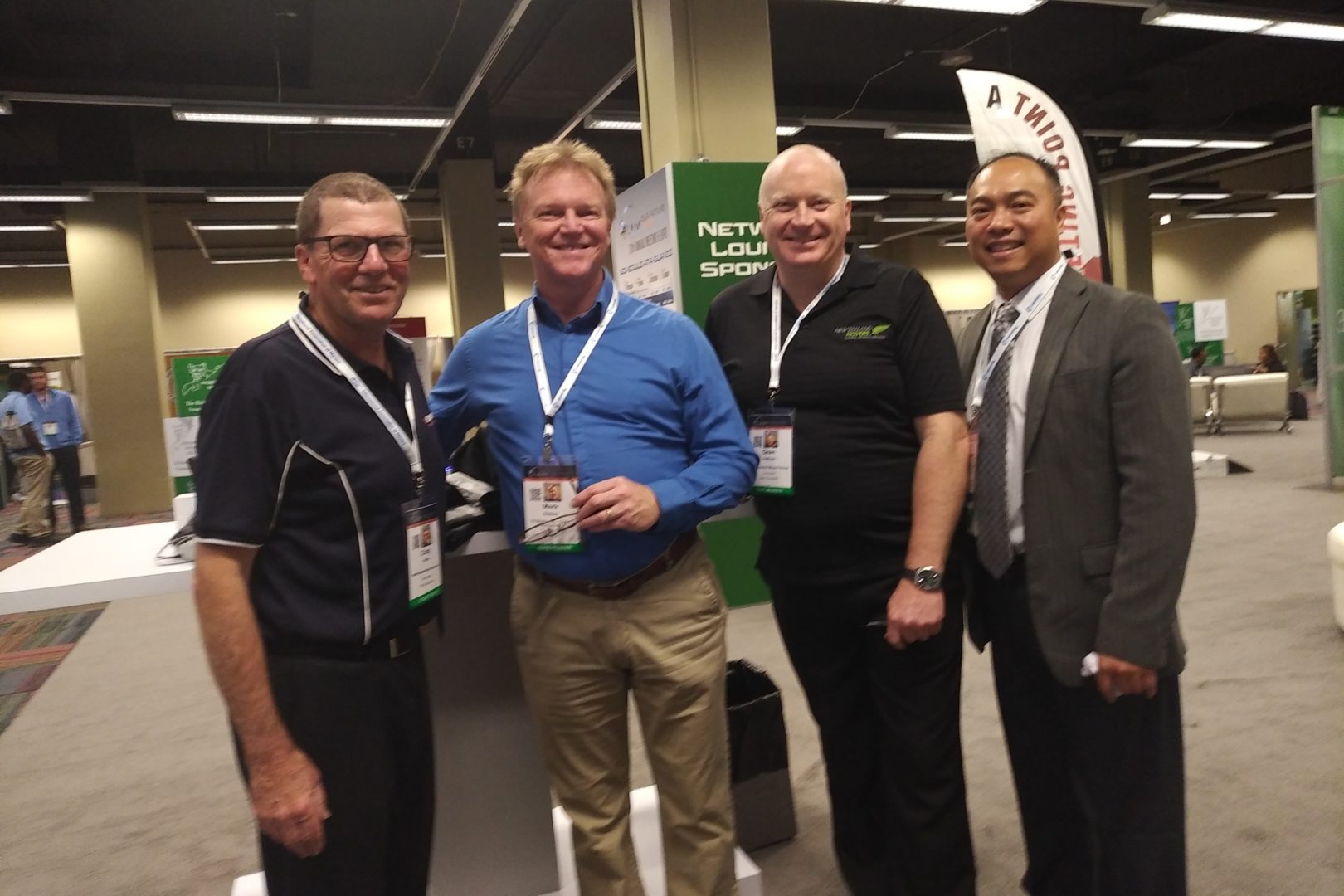 Four men posing for a picture at a conference