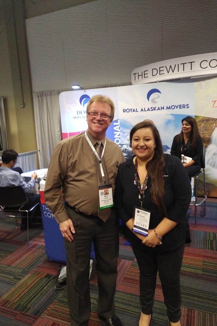 Man, and a lady posing for a picture at a conference