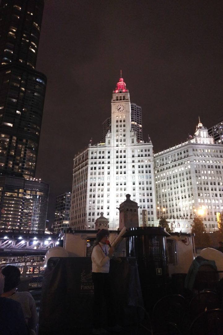 Lady in a white sweater speaking into a microphone on a water boat tour cruise